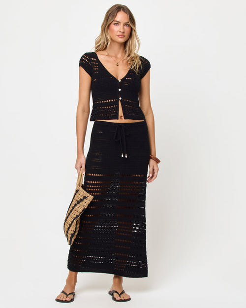 Front view of model wearing the LSPACE Tula Skirt in black, a semi-sheer crochet maxi skirt with drawstring waist, styled with a matching black crochet top.