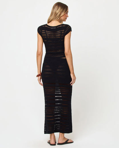 Back view of model wearing the LSPACE Tula Top in black, a semi-sheer crochet cropped top with the matching Skirt.