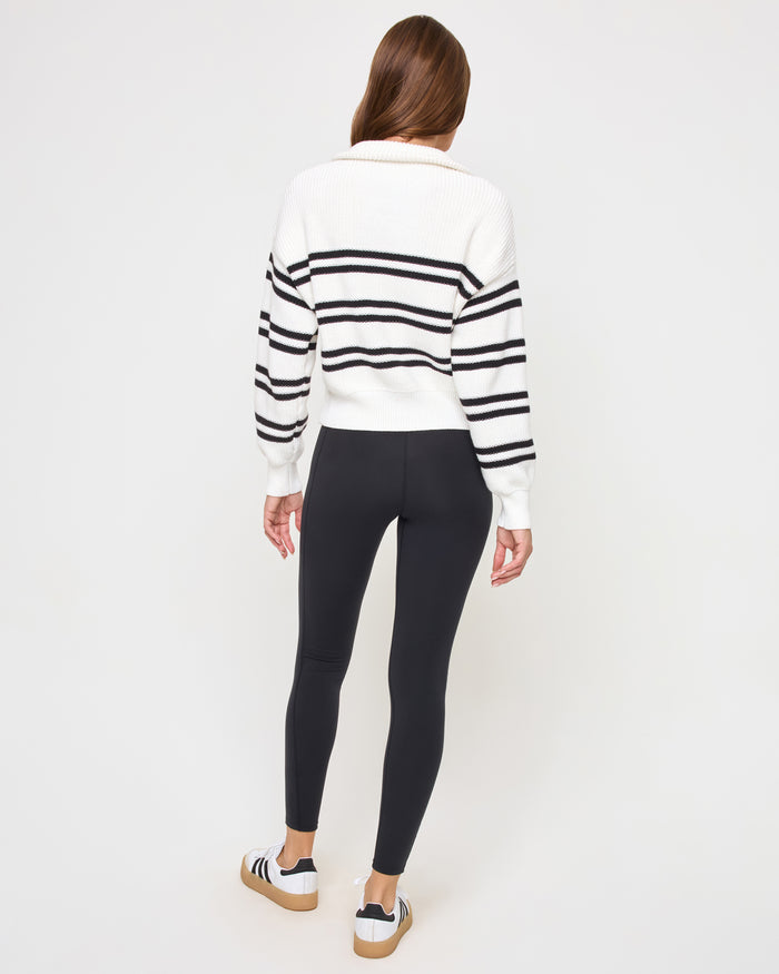 Back view of the LSPACE Ultra Stripe Sweater in black-white on a model, showing the back of the ribbed sweater with bold black and white horizontal stripes.
