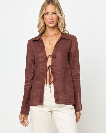 Front view of a model wearing the LSPACE Venice Shirt in cafe, an open linen shirt with a spread collar and double tie front closures, styled with white wide-leg pants.