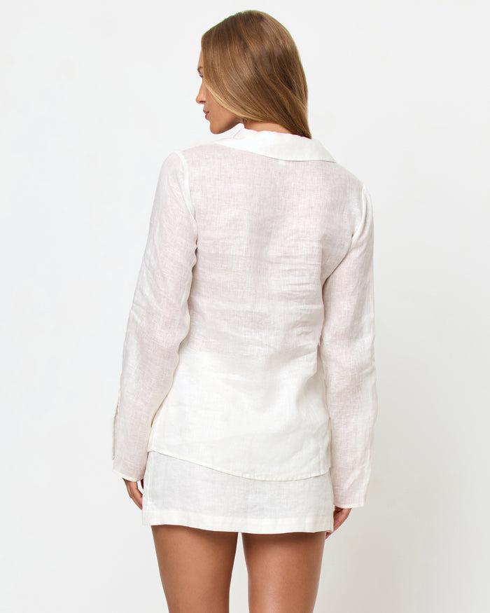 Back view of a model wearing the LSPACE Venice Shirt in white, showing the clean linen back construction, spread collar, and long sleeves, styled with the matching Venice Skort.