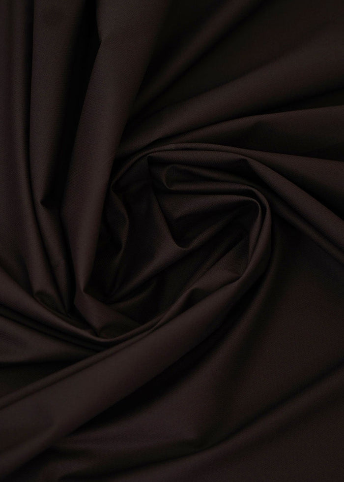 Dark chocolate-brown dobby fabric with raised geometric texture, close-up