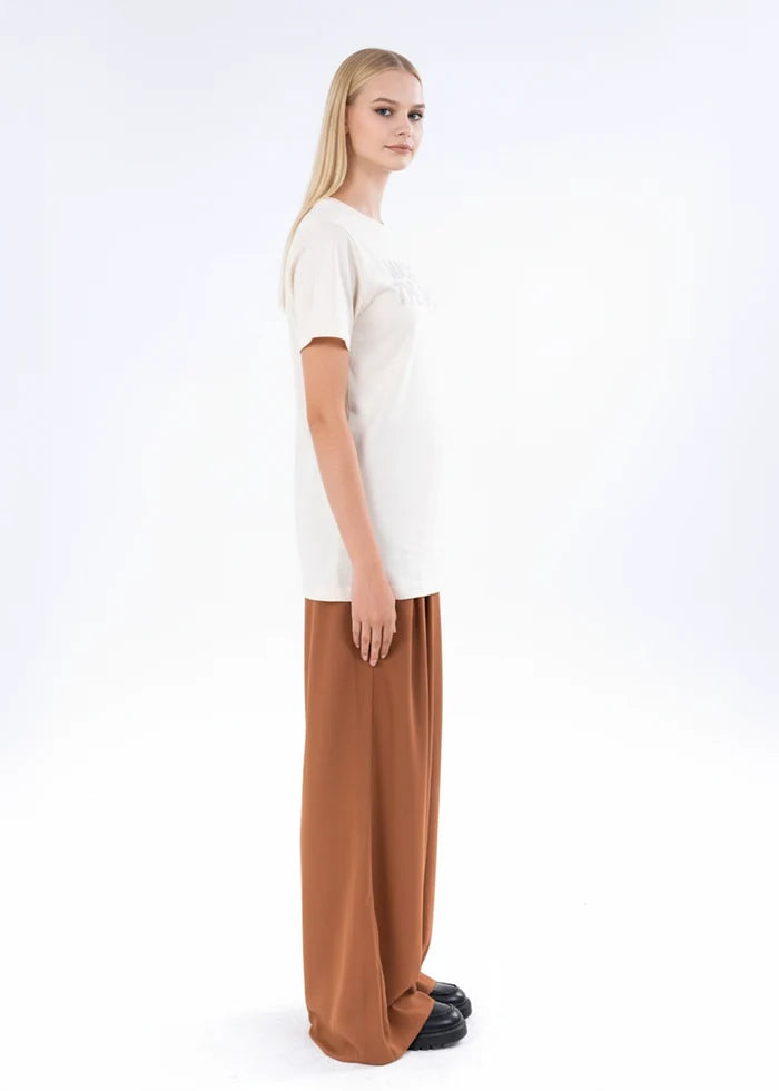 Off-white short-sleeve crewneck top shown from side with straight hem