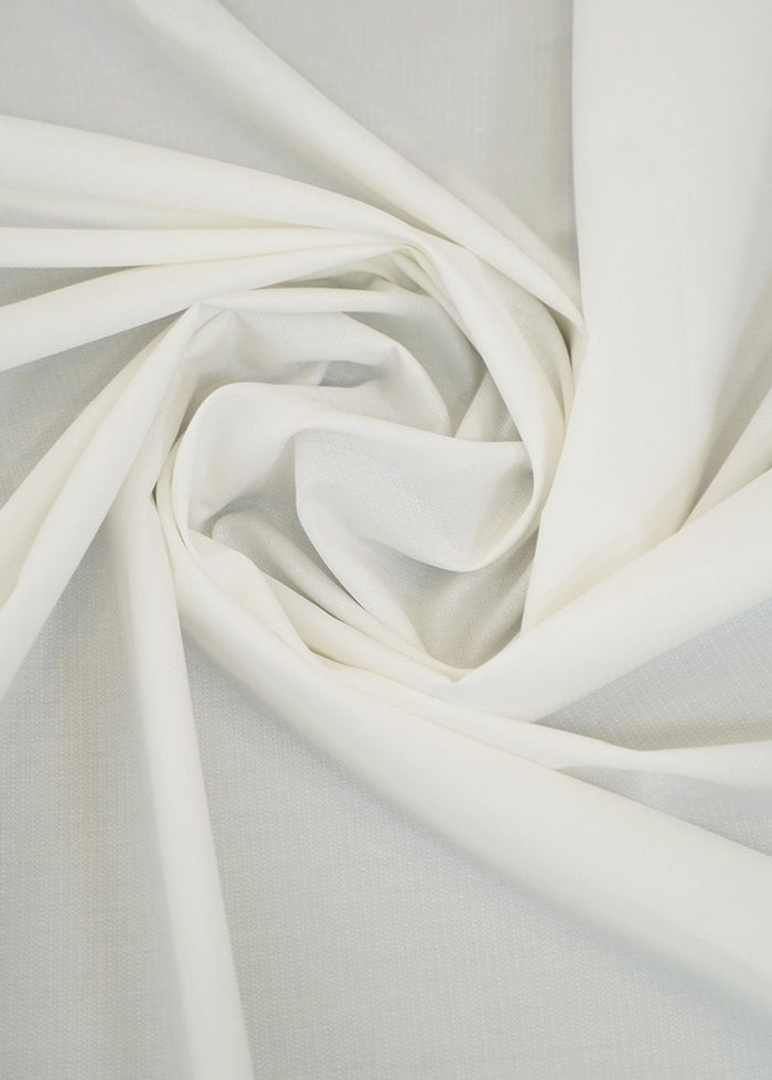 Off-white dobby fabric with woven texture, folded in soft folds