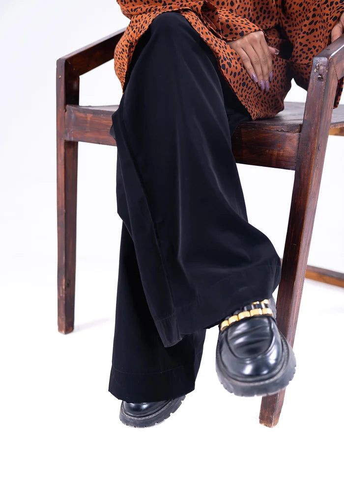 Women's winter pull-on black trousers, side close-up with wide hem and seam details