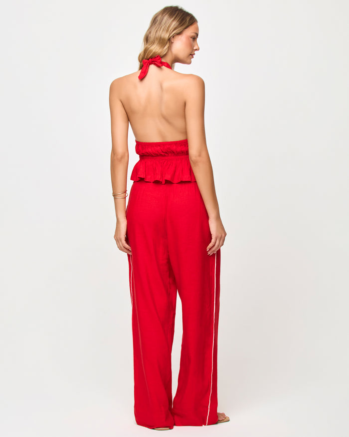 Back view of a model wearing the LSPACE x The Salty Blonde Sur Pant in flame-cream, showing the wide-leg silhouette with cream side-seam stripe detail, styled with a matching open-back halter top.